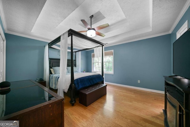 1769 Milford Creek Cts SW, Marietta, GA 30008 - bedroom featuring a textured ceiling, wood finished floors, crown molding, a ceiling fan, and a raised ceiling