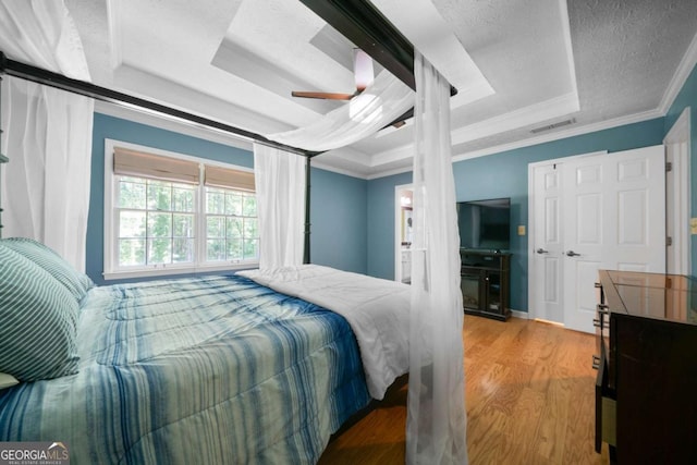 1769 Milford Creek Cts SW, Marietta, GA 30008 - bedroom featuring a raised ceiling, crown molding, wood finished floors, and ceiling fan