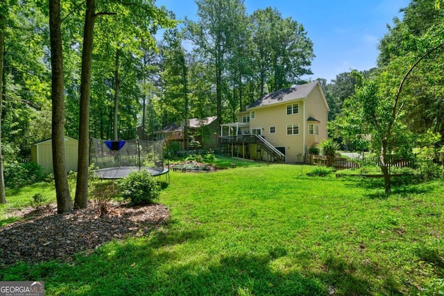1769 Milford Creek Cts SW, Marietta, GA 30008 - view of yard featuring a trampoline, stairs, a storage unit, and a deck