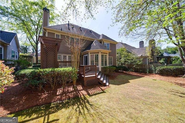 1021 Oakpointe Pl, Dunwoody, GA 30338 - back of property with a wooden deck, a lawn, and a chimney