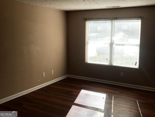 18101 Waldrop Cv, Decatur, GA 30034 - empty room featuring a textured ceiling, plenty of natural light, wood finished floors, and baseboards