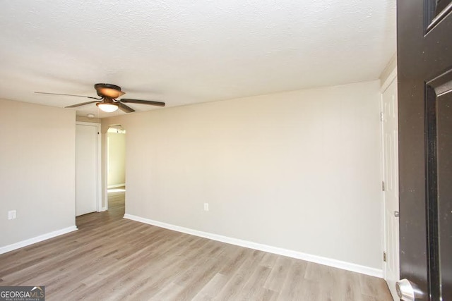 272 Old Sudie Rd, Hiram, GA 30141 - unfurnished room featuring light wood-style floors, a ceiling fan, a textured ceiling, and arched walkways