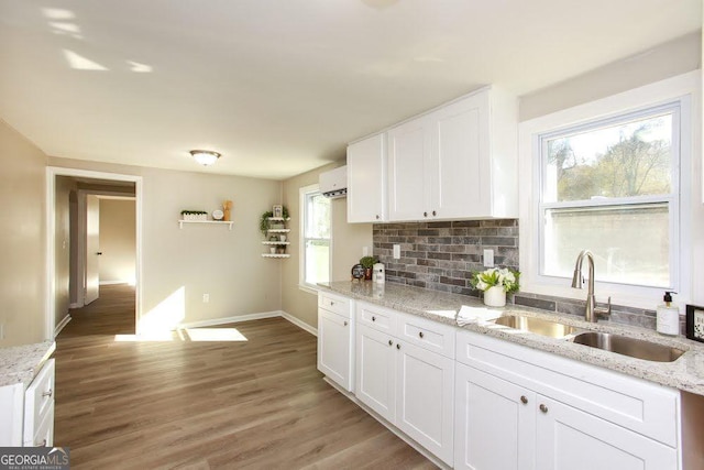 272 Old Sudie Rd, Hiram, GA 30141 - kitchen with white cabinets, light wood finished floors, backsplash, and light stone countertops