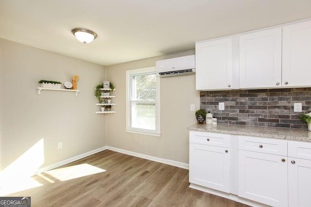 272 Old Sudie Rd, Hiram, GA 30141 - kitchen featuring a wall mounted air conditioner, wood finished floors, tasteful backsplash, and white cabinets