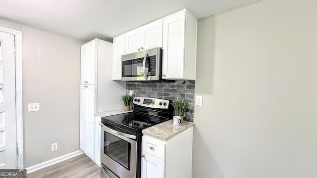 272 Old Sudie Rd, Hiram, GA 30141 - kitchen featuring appliances with stainless steel finishes, light wood-style floors, backsplash, white cabinetry, and light stone countertops