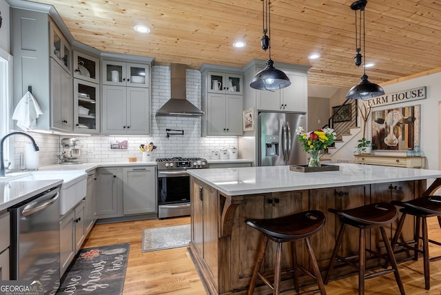724 Bertha Willis Rd, Carlton, GA 30627 - kitchen featuring wall chimney range hood, stainless steel appliances, wood ceiling, a kitchen island, and gray cabinetry
