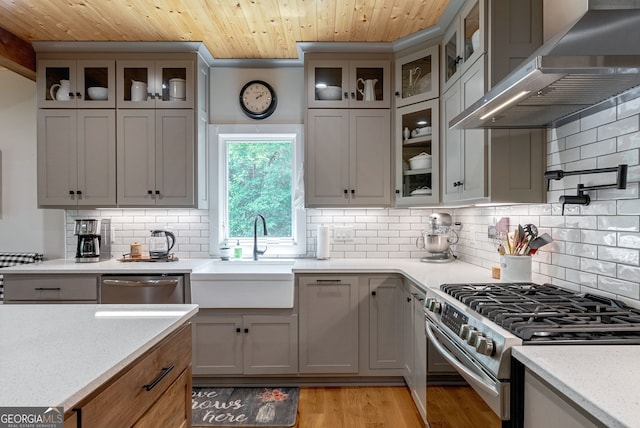 724 Bertha Willis Rd, Carlton, GA 30627 - kitchen with stainless steel appliances, wall chimney range hood, a sink, wooden ceiling, and tasteful backsplash