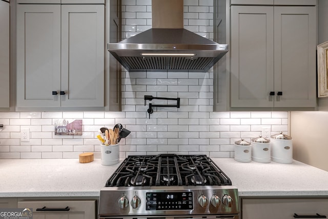 724 Bertha Willis Rd, Carlton, GA 30627 - kitchen featuring wall chimney range hood, gas stove, decorative backsplash, and light stone counters