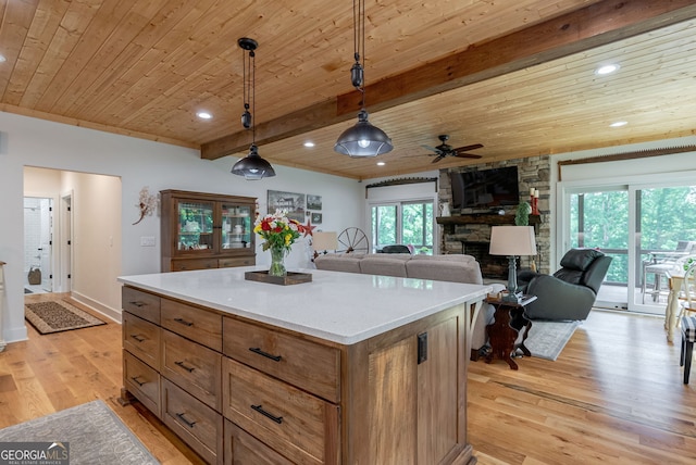 724 Bertha Willis Rd, Carlton, GA 30627 - kitchen featuring a ceiling fan, wood ceiling with exposed beams, a stone fireplace, light wood finished floors, and pendant lighting