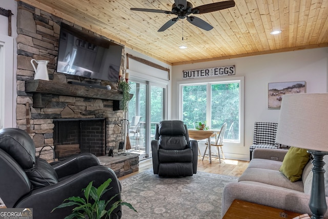 724 Bertha Willis Rd, Carlton, GA 30627 - living room with wood ceiling, wood finished floors, healthy amount of natural light, a stone fireplace, and ceiling fan