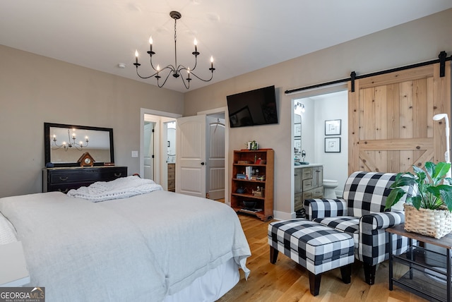724 Bertha Willis Rd, Carlton, GA 30627 - bedroom featuring a chandelier, light wood-style flooring, a barn door, ensuite bathroom, and baseboards