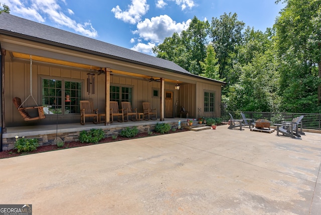 724 Bertha Willis Rd, Carlton, GA 30627 - back of house featuring board and batten siding, an outdoor fire pit, ceiling fan, and a patio