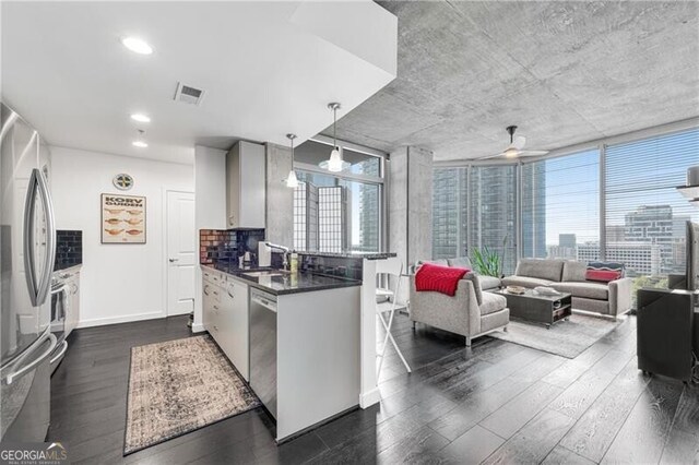 860 Peachtree St NE Unit 1502, Atlanta, GA 30308 - kitchen with dark countertops, dark wood-style floors, appliances with stainless steel finishes, a peninsula, and a ceiling fan