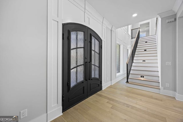 407 Thunder Rd, Buford, GA 30518 - entryway featuring french doors, light wood finished floors, stairway, arched walkways, and recessed lighting