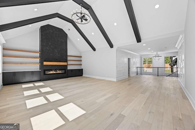 407 Thunder Rd, Buford, GA 30518 - unfurnished living room with a chandelier, a fireplace, beamed ceiling, wood finished floors, and high vaulted ceiling