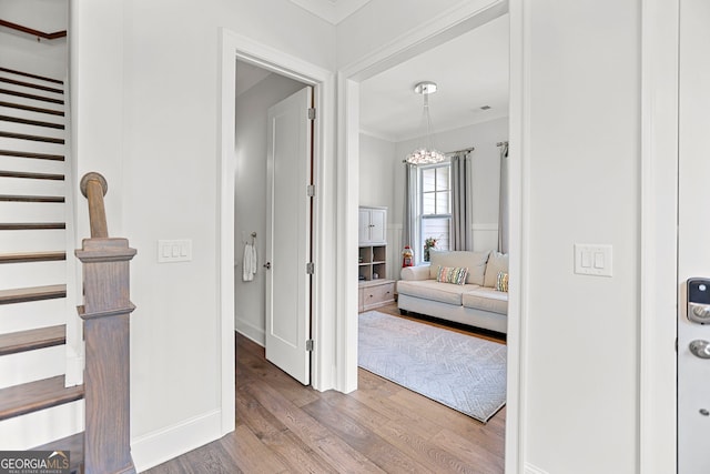 229 Widener Way, Peachtree City, GA 30269 - hallway featuring wood finished floors, stairway, ornamental molding, and a chandelier