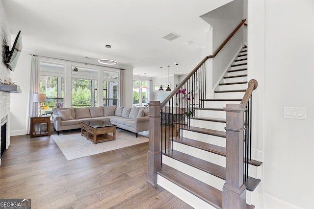 229 Widener Way, Peachtree City, GA 30269 - living area featuring a fireplace, stairway, wood finished floors, and baseboards