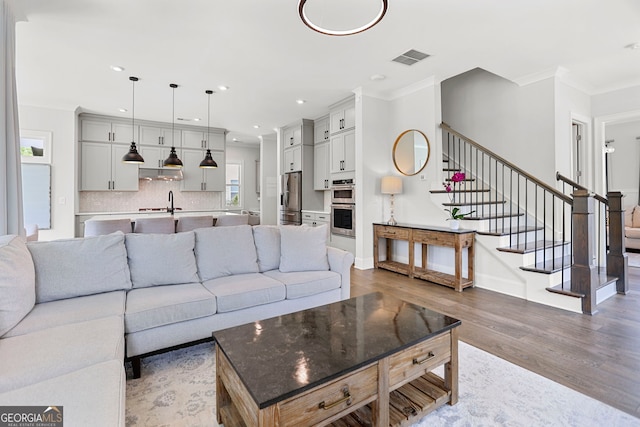 229 Widener Way, Peachtree City, GA 30269 - living room with stairs, wood finished floors, ornamental molding, recessed lighting, and baseboards