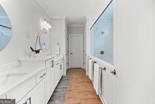 229 Widener Way, Peachtree City, GA 30269 - bathroom featuring double vanity, wood finished floors, a tile shower, and crown molding