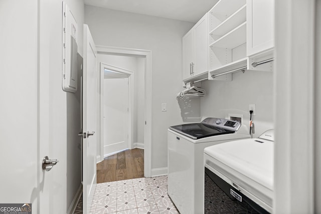 229 Widener Way, Peachtree City, GA 30269 - washroom featuring washing machine and dryer, cabinet space, baseboards, light tile patterned floors, and electric panel