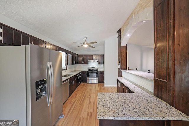4191 Alaina Cir, Austell, GA 30106 - kitchen with appliances with stainless steel finishes, light wood-style floors, ceiling fan, under cabinet range hood, and arched walkways