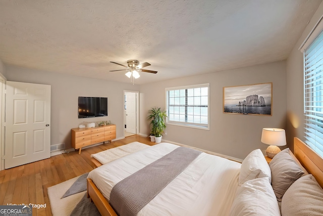 4191 Alaina Cir, Austell, GA 30106 - bedroom with baseboards, light wood-style floors, ceiling fan, and a textured ceiling