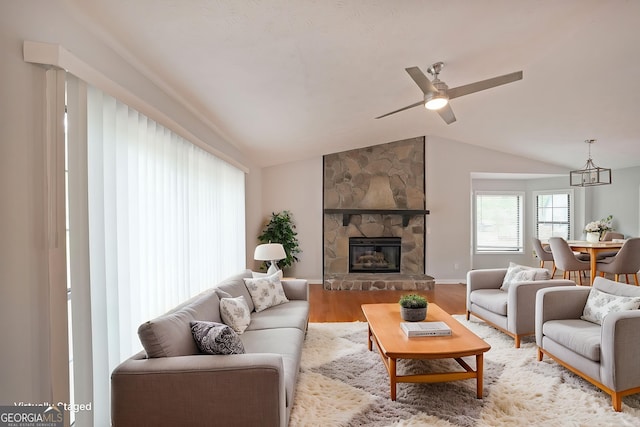4191 Alaina Cir, Austell, GA 30106 - living room featuring vaulted ceiling, wood finished floors, a chandelier, a stone fireplace, and ceiling fan