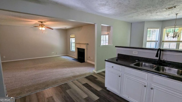 3881 Micah Ln, Ellenwood, GA 30294 - kitchen featuring a sink, a textured ceiling, dark wood finished floors, white cabinetry, and dark countertops