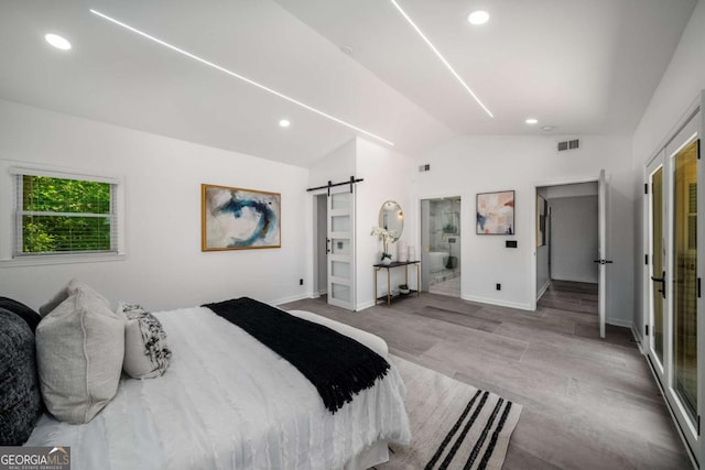 681 Fielding Ln SW, Atlanta, GA 30311 - bedroom with vaulted ceiling, a barn door, recessed lighting, and wood finished floors