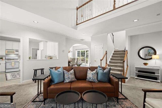 1050 Shady Valley Pl, Atlanta, GA 30324 - carpeted living area with arched walkways, stairway, baseboards, recessed lighting, and a high ceiling