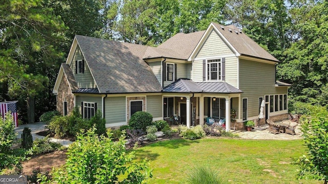 1323 Frey Lake Ct NW, Kennesaw, GA 30144 - view of front facade with a standing seam roof, a front yard, covered porch, metal roof, and a shingled roof