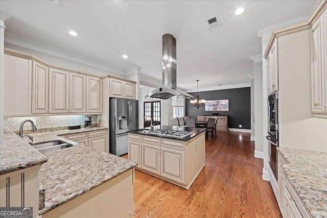 1323 Frey Lake Ct NW, Kennesaw, GA 30144 - kitchen featuring island exhaust hood, cream cabinetry, a sink, stainless steel appliances, and crown molding