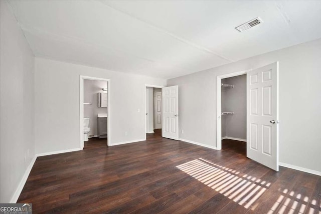 5555 Mountain Springs Cir, Stone Mountain, GA 30088 - unfurnished bedroom with wood finished floors, a walk in closet, a closet, and connected bathroom