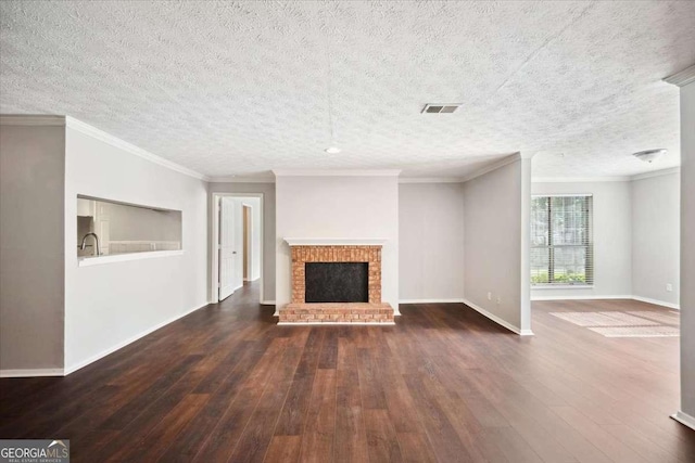 5555 Mountain Springs Cir, Stone Mountain, GA 30088 - unfurnished living room with hardwood / wood-style flooring, baseboards, a textured ceiling, a brick fireplace, and crown molding