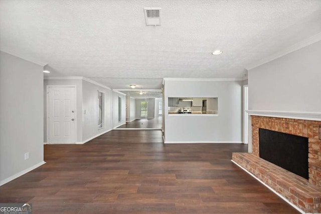 5555 Mountain Springs Cir, Stone Mountain, GA 30088 - unfurnished living room featuring a brick fireplace, crown molding, a textured ceiling, wood finished floors, and baseboards