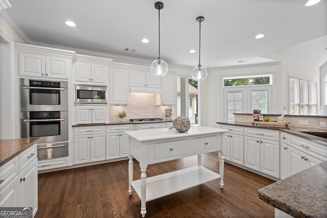10630 N Edgewater Pl, Johns Creek, GA 30097 - kitchen with appliances with stainless steel finishes, decorative backsplash, a warming drawer, white cabinetry, and crown molding