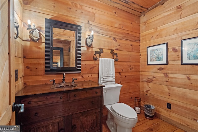 10630 N Edgewater Pl, Johns Creek, GA 30097 - half bath with toilet, vanity, wooden walls, and wood finished floors