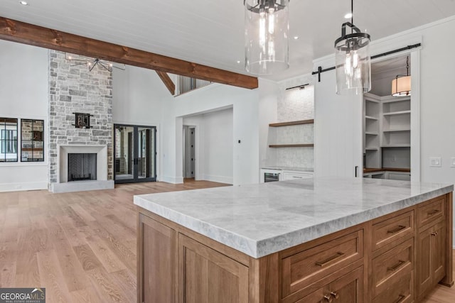 1111 Longview Commons, Greensboro, GA 30642 - kitchen with a barn door, open shelves, ceiling fan, brown cabinets, and light stone counters