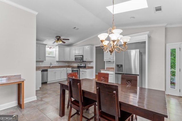 160 Birch Rd, Covington, GA 30014 - dining space featuring a chandelier, a skylight, light tile patterned floors, crown molding, and lofted ceiling