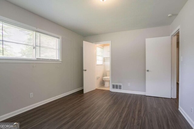2311 Cherry Blossom Dr SW, Atlanta, GA 30331 - unfurnished bedroom featuring dark wood finished floors, multiple windows, baseboards, and ensuite bath