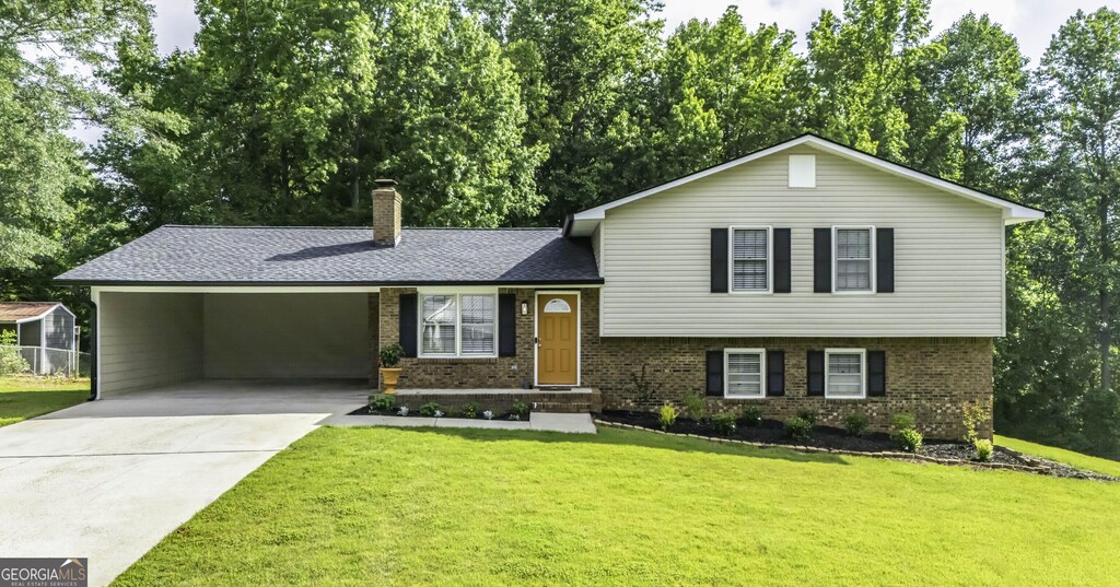 275 Timber Ridge Trl, Carrollton, GA 30117 - tri-level home featuring brick siding, driveway, a chimney, and a front lawn
