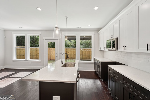 1158 Welch St SW, Atlanta, GA 30310 - kitchen with stainless steel microwave, plenty of natural light, light stone countertops, white cabinetry, and recessed lighting