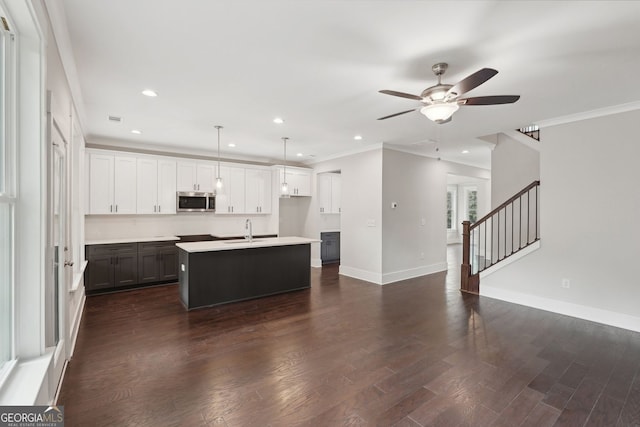 1158 Welch St SW, Atlanta, GA 30310 - kitchen featuring stainless steel microwave, ceiling fan, crown molding, an island with sink, and open floor plan