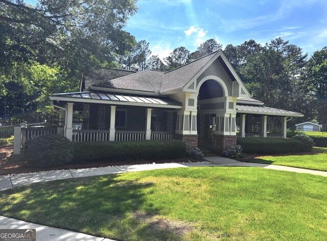 2674 Misty Rock Cv, Dacula, GA 30019 - view of front of home featuring covered porch, a standing seam roof, a front yard, metal roof, and brick siding
