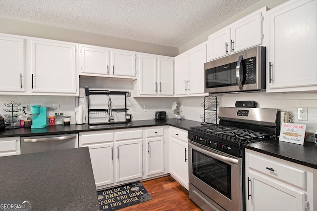 1478 Interlaken Pass, Jonesboro, GA 30238 - kitchen featuring stainless steel appliances, white cabinetry, dark countertops, and a textured ceiling
