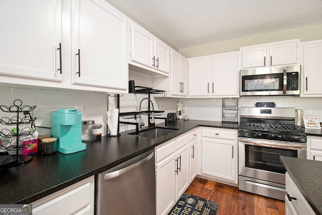 1478 Interlaken Pass, Jonesboro, GA 30238 - kitchen featuring stainless steel appliances, white cabinets, decorative backsplash, dark countertops, and dark wood-style floors