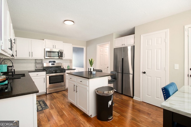 1478 Interlaken Pass, Jonesboro, GA 30238 - kitchen featuring appliances with stainless steel finishes, dark wood finished floors, white cabinets, and a textured ceiling