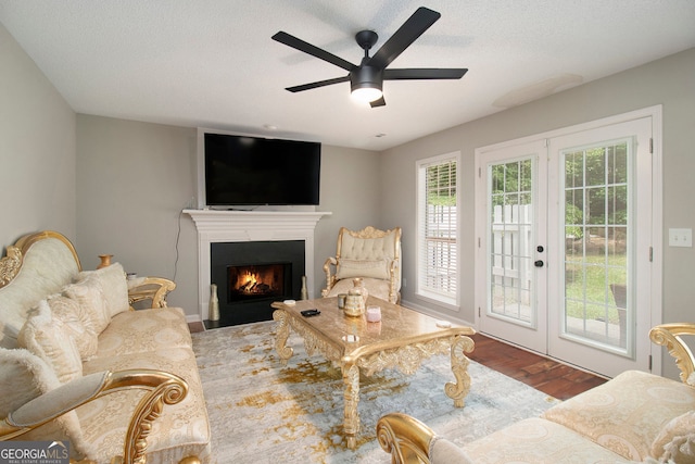 1478 Interlaken Pass, Jonesboro, GA 30238 - living area with wood finished floors, a fireplace with flush hearth, a ceiling fan, a textured ceiling, and french doors