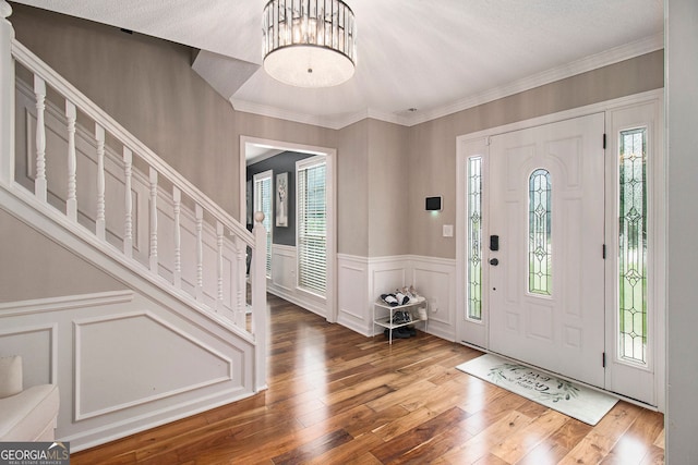 1478 Interlaken Pass, Jonesboro, GA 30238 - foyer featuring a decorative wall, wood finished floors, wainscoting, crown molding, and stairway