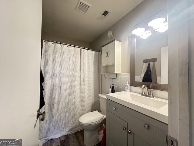 1815 Oak Spring St, Statham, GA 30666 - bathroom with wood finished floors, toilet, vanity, a shower with curtain, and tasteful backsplash